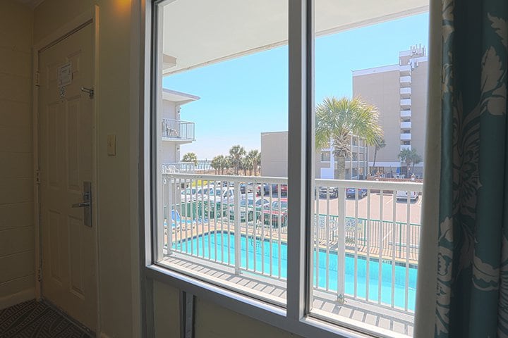 A room with a view of the pool and balcony